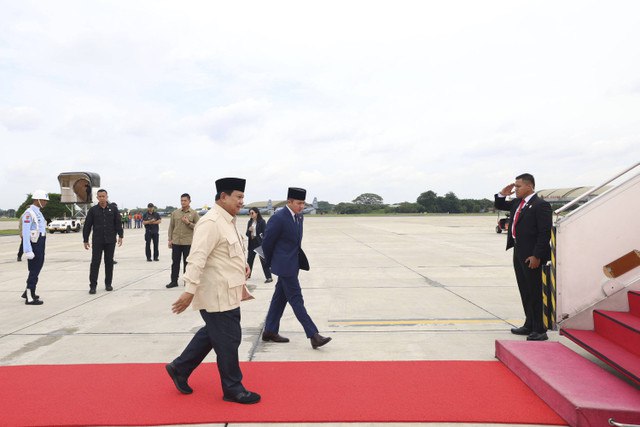 Presiden Prabowo Subianto berjalan menuju pesawat didampingi Sekertaris Kabinet Teddy Indra Wijaya sebelum melakukan kunjungan ke luar negeri di Pangkalan TNI AU Halim Perdanakusama, Jakarta, Selasa (17/12/2024). Foto: Dok. Istimewa