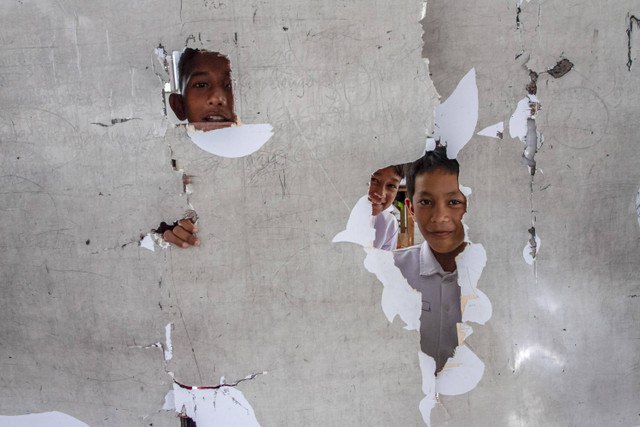 Tiga siswa bermain di ruang kelas SD Negeri Karangbolong 2, Cigeulis, Kabupaten Pandeglang, Banten, Senin (11/11/2024). Foto: Angga Budhiyanto/ ANTARA FOTO