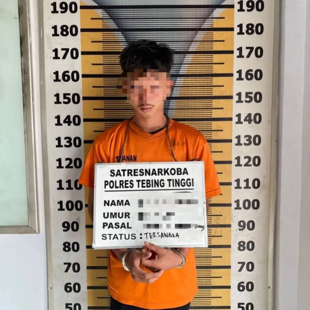 Tersangka MRH (19) saat berada di Kantor Sat Resnarkoba Polres Tebing Tinggi, tangan diborgol dan mengenakan baju Tahanan Orange. Foto: Dok. Polres Tebing Tinggi.