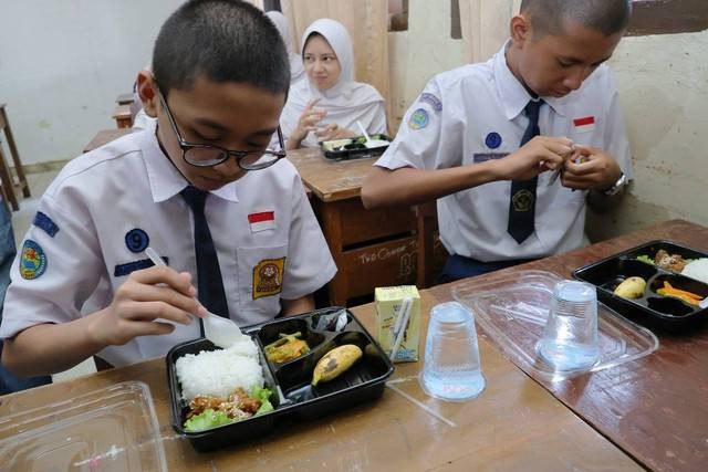 Siswi SMP di Palembang saat menikmati makan bergizi gratis. Foto: Dok Kominfo Palembang