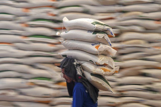 Pekerja memanggul karung berisi beras yang akan didistribusikan di Gudang Bulog Karang Asam Ulu II, Samarinda, Kalimantan Timur, Rabu (11/12/2024). Foto: M Risyal Hidayat/ANTARA FOTO