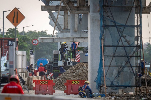 Pekerja menyelesaikan proyek pembangunan Jalan Tol Harbour Road II yang menghubungkan Ancol Timur dan Pluit di kawasan Pandemangan, Jakarta Utara, Kamis (30/5/2024). Foto: Erlangga Bregas Prakoso/ANTARA FOTO