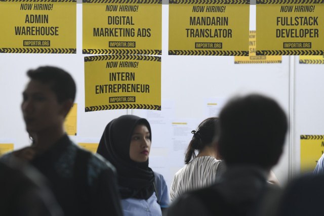 Pencari kerja melintasi salah satu perusahaan yang membuka lowongan saat Pameran Bursa Kerja di Stadion Gelora Bung Karno, Jakarta. Foto: ANTARA FOTO/Wahyu Putro A