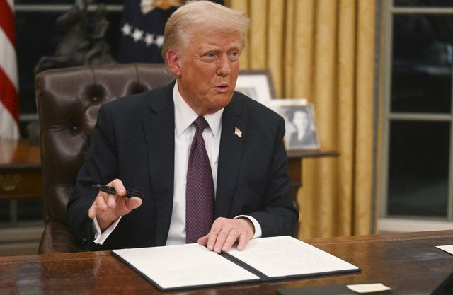 Presiden AS Donald Trump menandatangani perintah eksekutif di Ruang Oval Gedung Putih di Washington DC, Amerika Serikat, Selasa (21/1/2025). Foto: Jim Watson/AFP