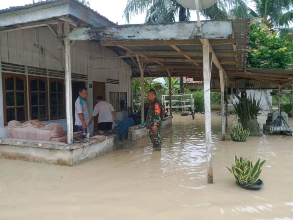 Babinsa saat pantau Dua Desa yang terendam banjir di dolok Masihul. Foto: Istimewa.