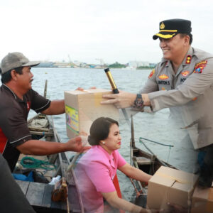 Kapolres Belawan Janton Silaban bersama ketua Bhanyangkara Cabang Pelabuhan Belawan Frisca Janton Silaban saat membagikan Takjil da Sembako kepada Nelayan. Foto: Dok. Polres Pelabuhan Belawan.