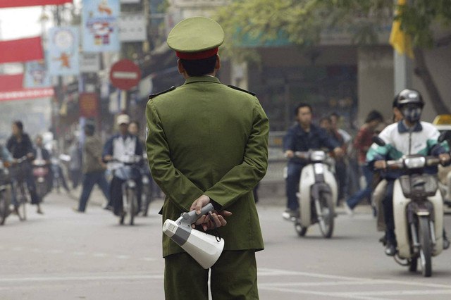 Seorang polisi berjaga di sebuah jalan yang sibuk di pusat kota Hanoi (2/12/2003). Foto: Hoang Dinh Nam/AFP